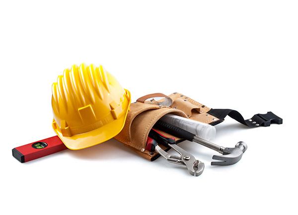Pile of tools in a tool belt and yellow hard hat